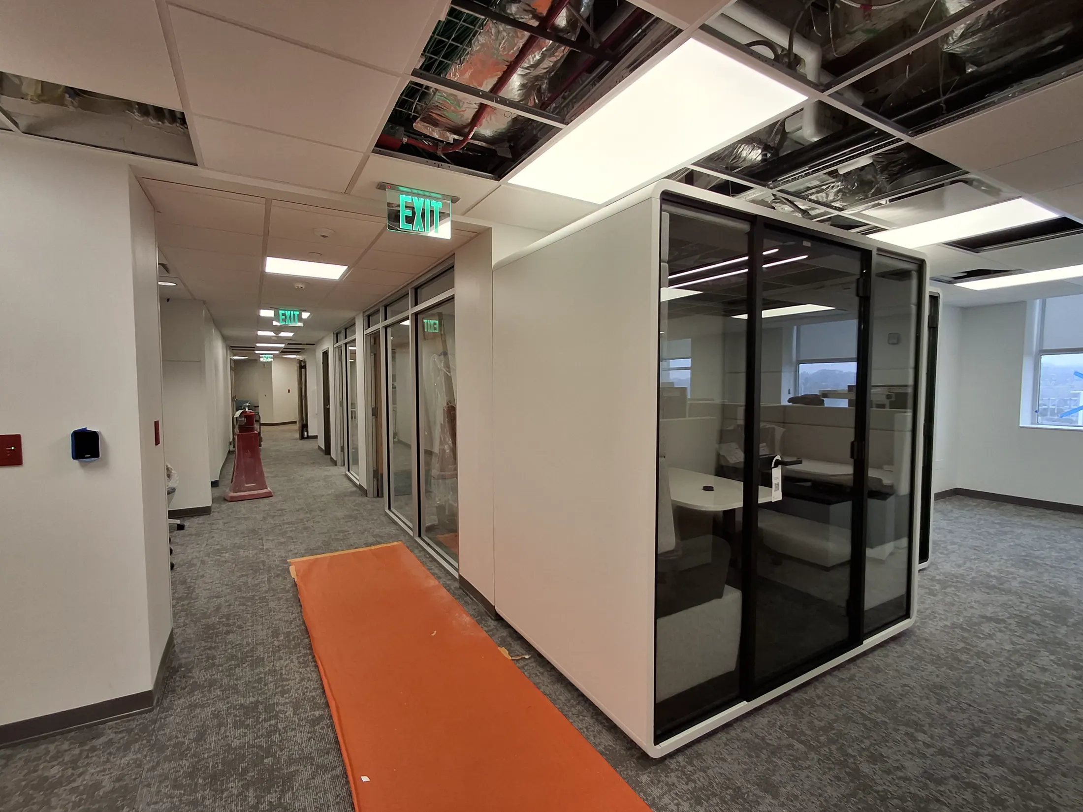 Tower C Integrated Care Campus corridor during fit-out, with glazed rooms and temporary floor protection