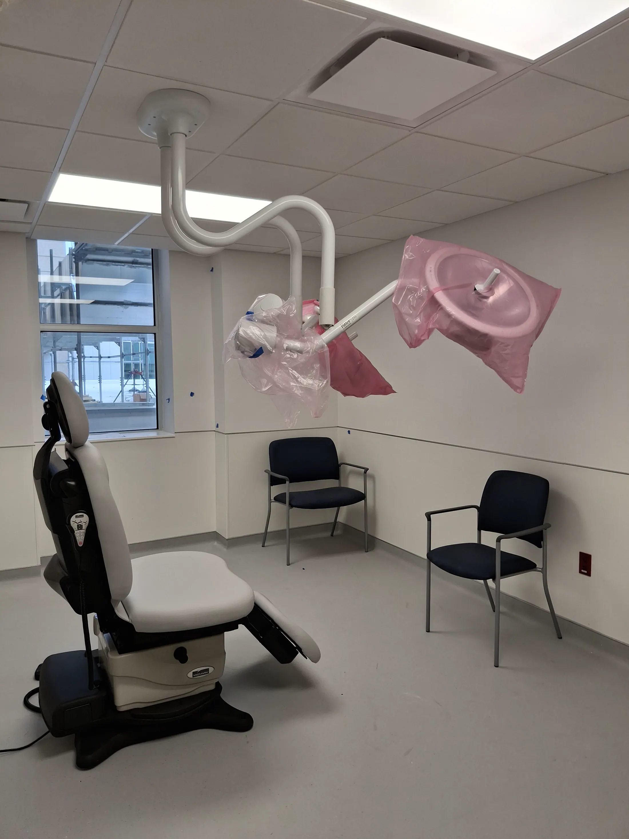 Procedure room with ceiling-mounted equipment and patient seating